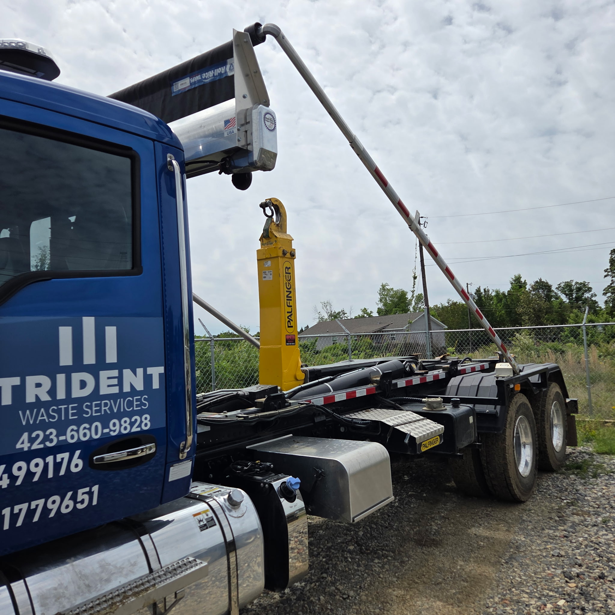 Close-up of a Trident roll-off truck's hydraulic hoist arm