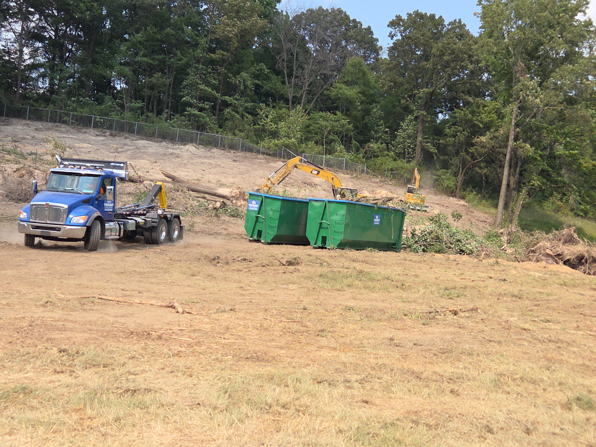 Trident truck and roll-off dumpsters at a Chattanooga land-clearing site
